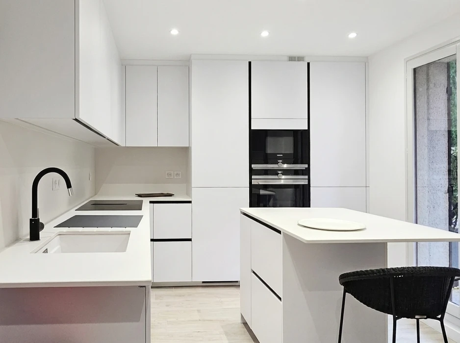 Cuisine moderne minimaliste entièrement blanche, configuration en L avec îlot central