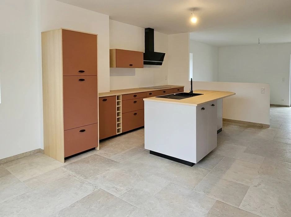 Cuisine moderne ouverte sur séjour, îlot central blanc avec plan de travail bois, évier noir encastré