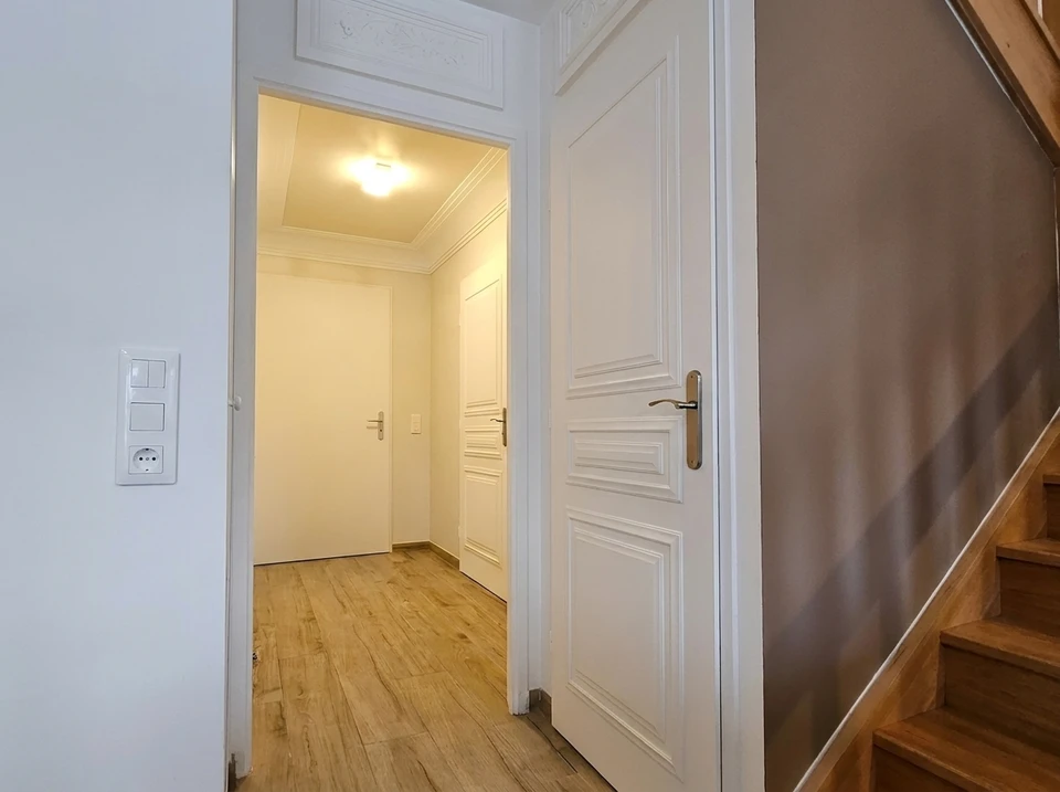 Couloir d'entrée lumineux avec parquet stratifié chêne clair
