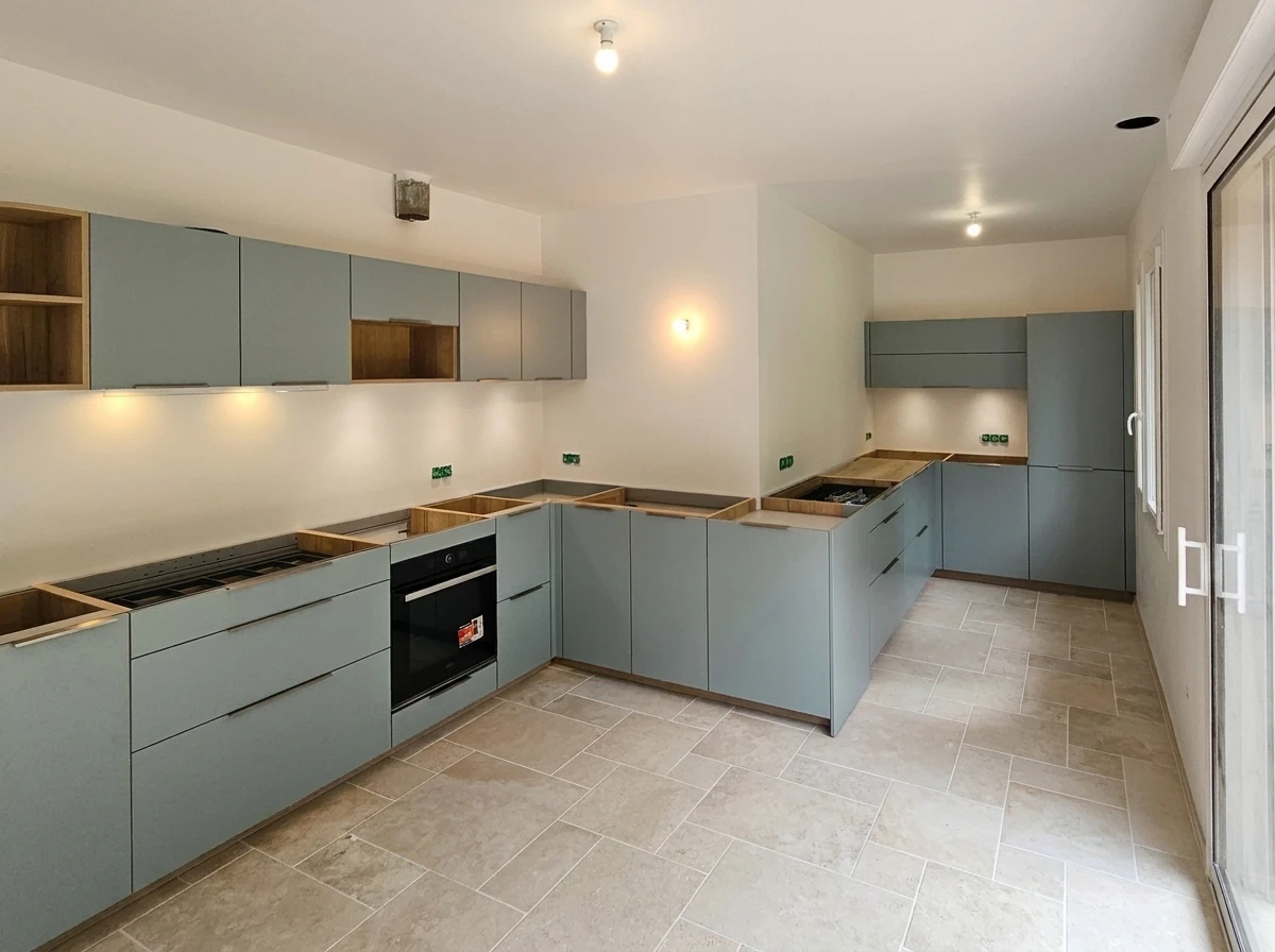 Cuisine moderne ouverte avec îlot central, plan de travail en quartz blanc, façades laquées grises, crédence miroir